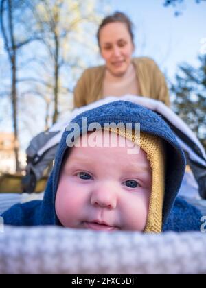 Cute baby girl with mother in background at playground Stock Photo