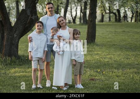 Happy harmonious family with three kids outdoors. Family portrait in park. Stock Photo