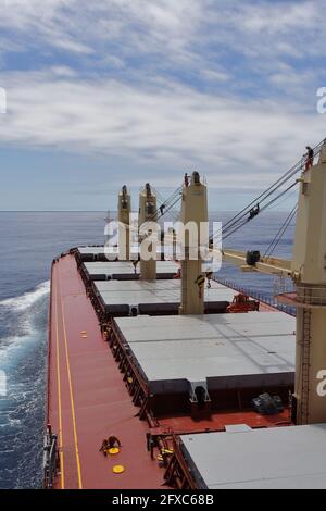 Maintenance work never ends on board. Deck crew lubricate crane wires before entering port