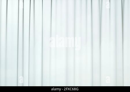 Light coming through a sheer, transparent and pleated white curtains or drapes. Striped, vertical linear patterns. Abstract full frame background. Stock Photo