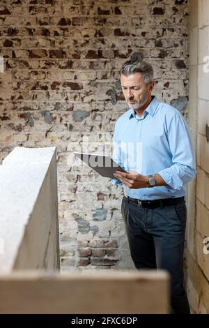 Male architect using digital tablet at construction site Stock Photo