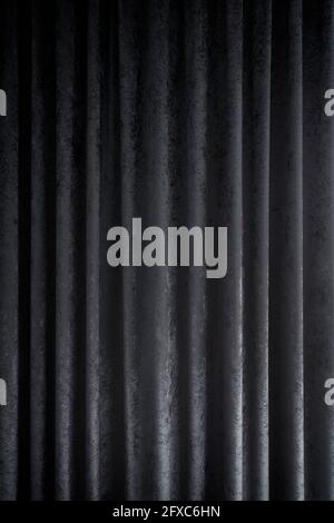 Front view of a folded dark gray curtains or drapes. Abstract high resolution full frame textured background. Stock Photo