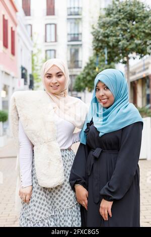Young women wearing hijab standing on footpath Stock Photo