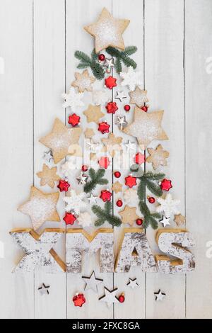 Arrangement of homemade cookies and various Christmas decorations hanging on wooden wall Stock Photo