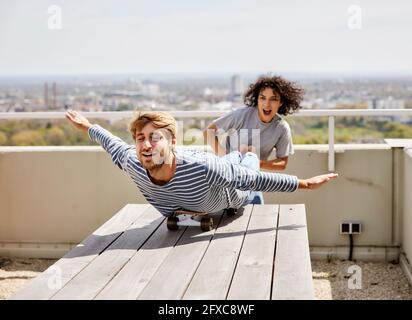 Young woman holding boyfriend leg while enjoying on terrace Stock Photo