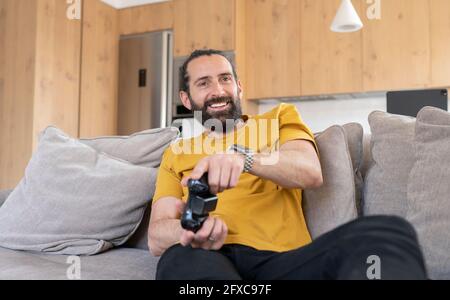 Happy man playing video game at home Stock Photo