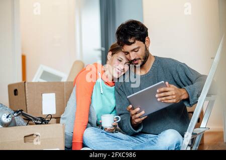 Young couple using digital tablet at new home Stock Photo