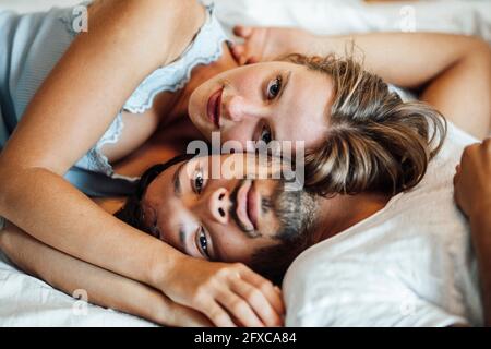 Romantic young couple lying on bed at home Stock Photo