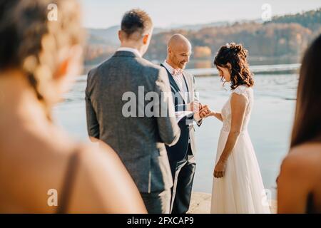 Bride and groom exchanging wedding rings during ceremony Stock Photo