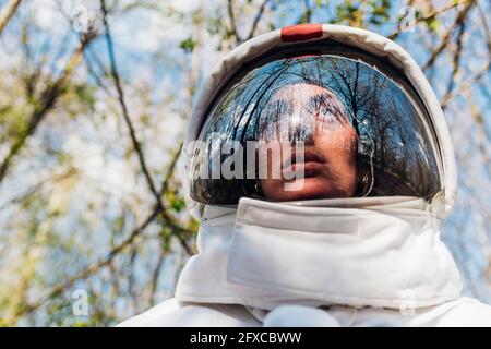 Female explorer with space helmet in forest Stock Photo