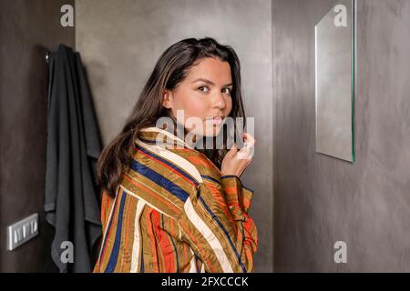 Mid adult woman staring while standing in bathroom Stock Photo