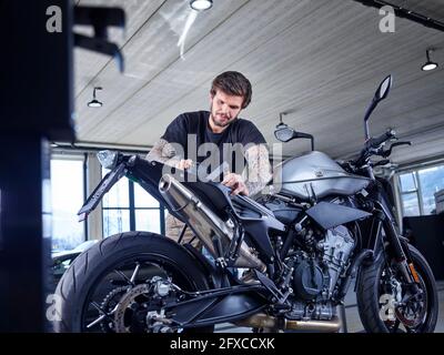 Male technician working on vehicle seat at garage Stock Photo