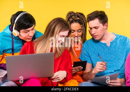 Young friends studying through digital tablet together Stock Photo