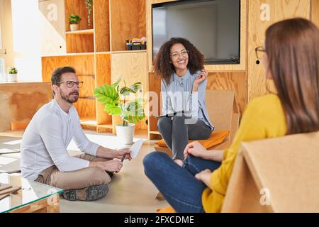 Entrepreneurs discussing while sitting in creative office Stock Photo