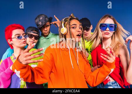 Cool friends dancing together in front of blue background Stock Photo