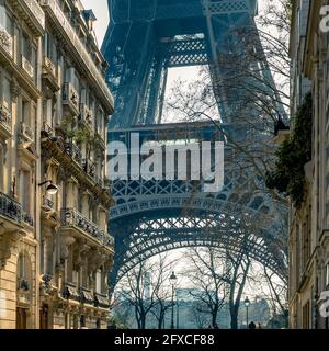 Paris, France - March 8, 2021: Cozy street with view of Eiffel Tower in Paris. Eiffel Tower is one of the most iconic landmarks