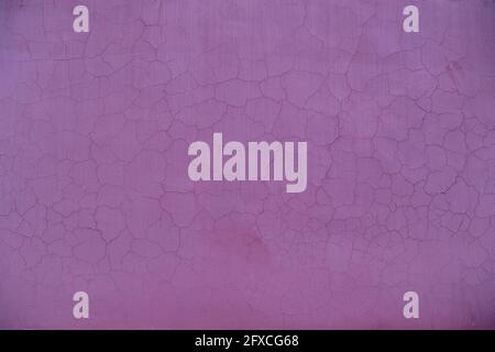 cracked purple painted plaster wall texture and background. Stock Photo