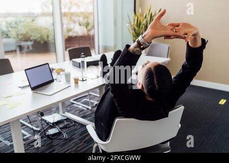 Young professional resting on chair in office Stock Photo