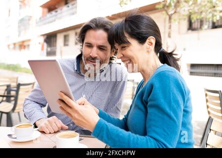 Man and woman using digital tablet at terrace Stock Photo