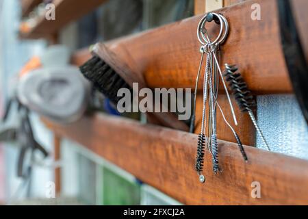 Brush and work tools hanging on wood at workshop Stock Photo