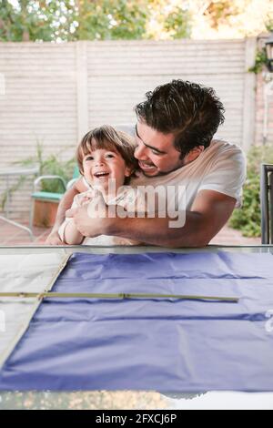 Playful father with cute son in back yard Stock Photo