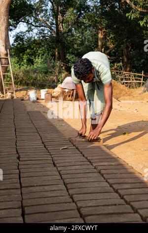 Men making clay bricks by hand in a rural village in Nayagarh, Odisha. Stock Photo