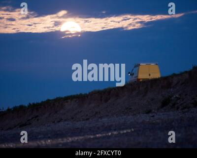 Minster on Sea, Kent, UK. 26th May, 2021. UK Weather: the full super flower moon seen rising in Minster on Sea, Kent this evening. Credit: James Bell/Alamy Live News Stock Photo