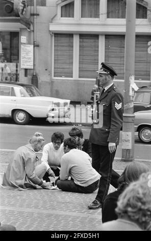 Policeman walks among young people, July 5, 1970, youth, monuments, policemen, subcultures, tourism, The Netherlands, 20th century press agency photo, news to remember, documentary, historic photography 1945-1990, visual stories, human history of the Twentieth Century, capturing moments in time Stock Photo