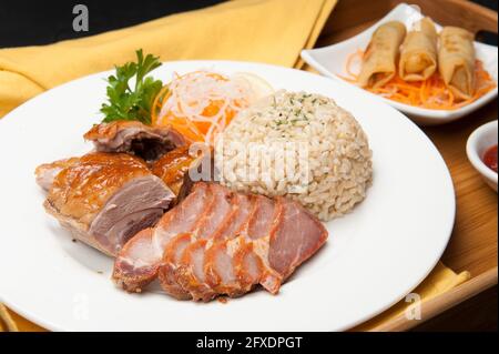 Pork belly, brown rice, and spring rolls at a Korean restaurant. Stock Photo