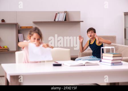 Teenager and his small sister staying at home during pandemic Stock Photo