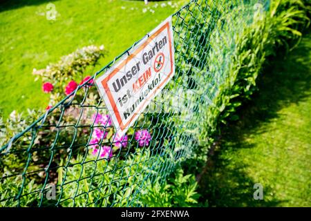 Berlin, Germany. 26th May, 2021. A sign saying 'Our garden is not a dog's litter box!' hangs on a fence in an allotment colony. (to dpa 'More quarrels among neighbours - arbitration popular') Credit: Christoph Soeder/dpa/Alamy Live News Stock Photo