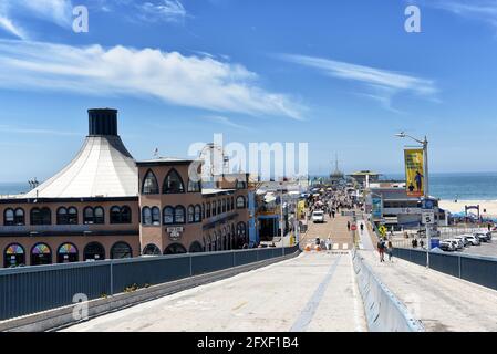 SANTA MONICA, CALIFORNIA - 25 MAY 2021: The historic Pier with the Merry-go-Round building, restaurants and Pacific Park amusement rides. Stock Photo