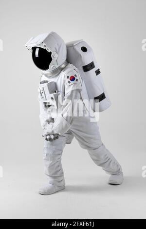 Astronaut stretching before exercise, white background Stock Photo