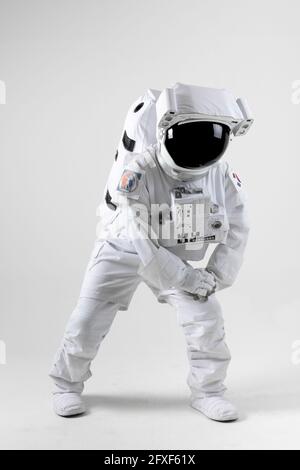 Astronaut stretching before exercise, white background Stock Photo