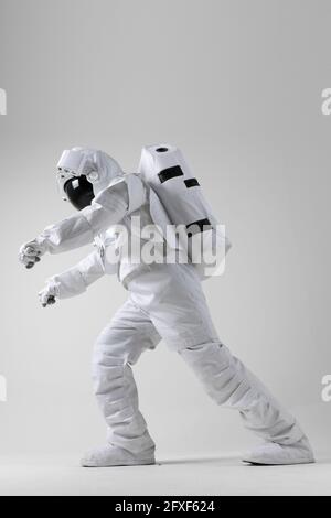 Astronaut stretching before exercise, white background Stock Photo