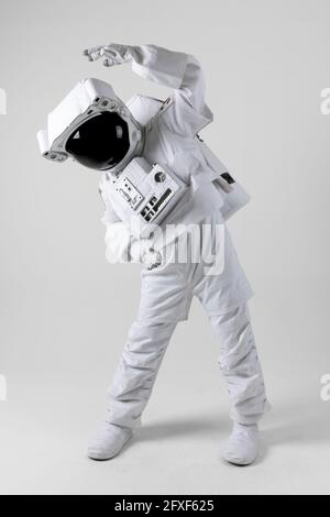 Astronaut stretching before exercise, white background Stock Photo