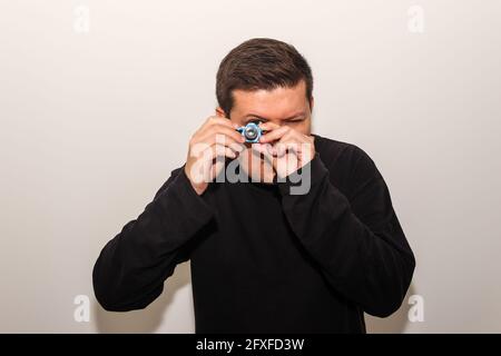 Brazilian male taking a photo with a toy camera Stock Photo
