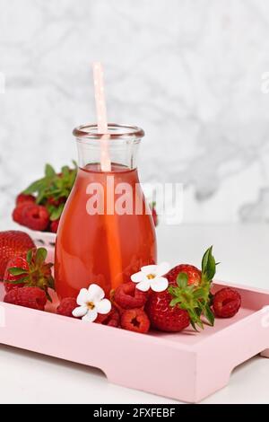 Red strawberry fruit lemonade in jar surrounded by berries Stock Photo