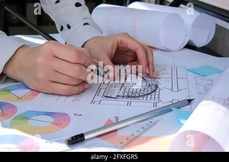 Hands use pencil with a protractor. Architectural Project drawings with tools. Architects workplace. Engineering Interior designer's working table. Wo Stock Photo