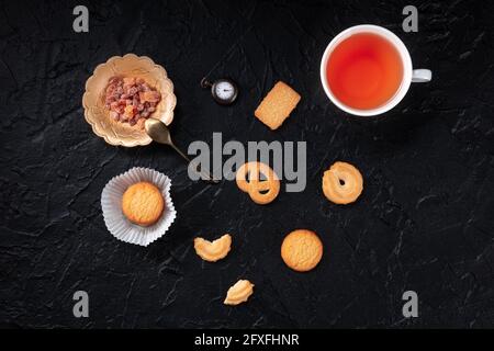 Danish butter cookies and five o'clock tea, top shot on a black background Stock Photo