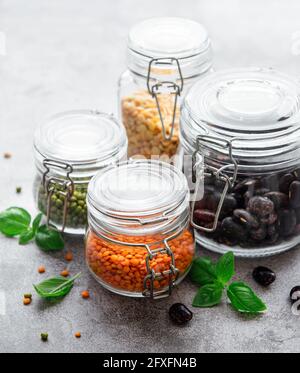 Jars with different cereal grains on marble table Stock Photo - Alamy