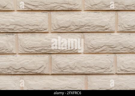 Beige brick wall texture. The exterior wall of a building with dust and dirt. Daytime. Stock Photo