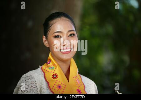 Portrait of a Burmese girl with traditional Thanaka face painting in front of golden Pagoda Stock Photo