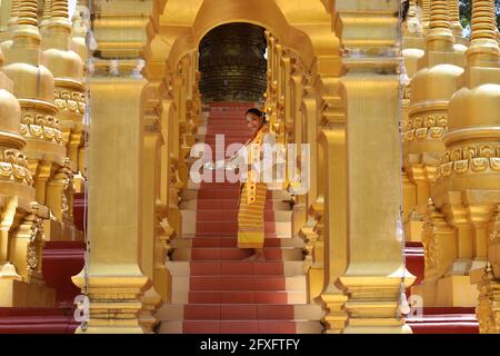 Myanmar women holding flowers at a temple. Southeast Asian young girls with burmese traditional dress visiting a Buddihist temple Stock Photo