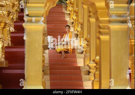 Myanmar women holding flowers at a temple. Southeast Asian young girls with burmese traditional dress visiting a Buddihist temple Stock Photo