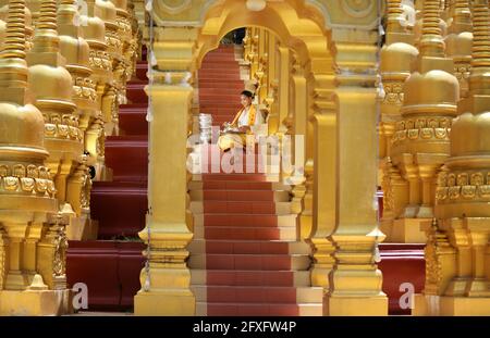 Myanmar women holding flowers at a temple. Southeast Asian young girls with burmese traditional dress visiting a Buddihist temple Stock Photo