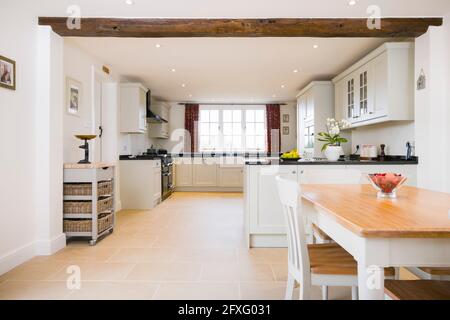 Open plan farmhouse kitchen dining room, with modern painted wood modular kitchen units, UK interior design Stock Photo