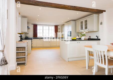 Painted wood modular kitchen furniture design in off white with porcelain tile floor, UK luxury kitchens Stock Photo