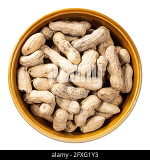 top view of unpeeled peanuts in round ceramic bowl cutout on white background Stock Photo