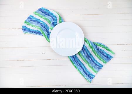 Empty white plate and towel on a wooden background. Stock Photo